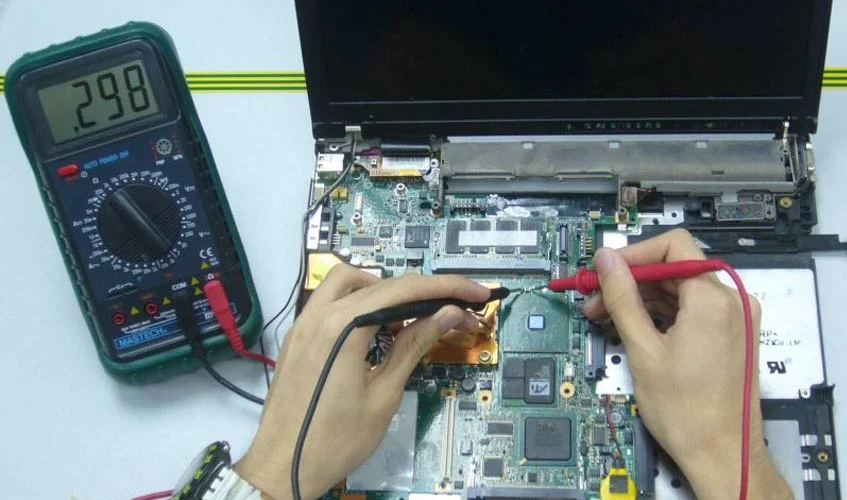 Technician repairing a laptop at the Denofix workbench
